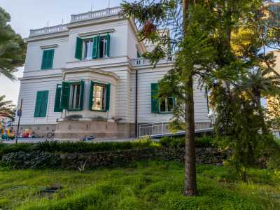 Spostandoci sul fianco destro notiamo come la composizione architettonica si arricchisca di altri particolari elementi, non frequenti nelle dimore baresi, come il bovindo, scandito da colonne e finestre con persiane verdi